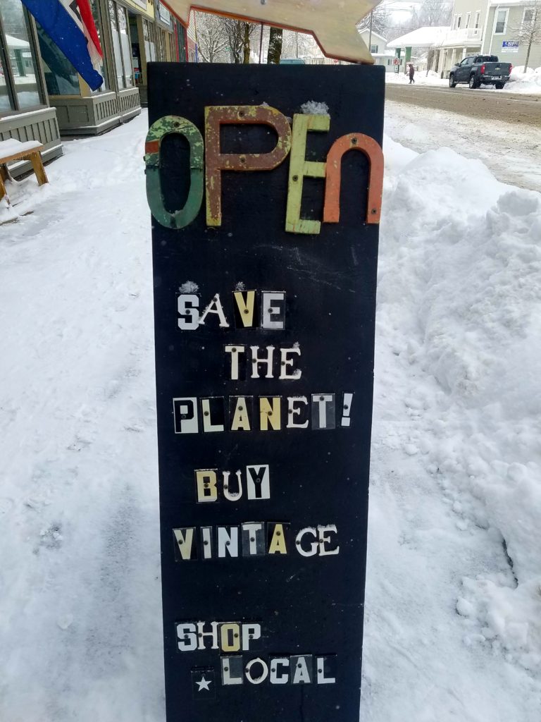 sign about saving the planet, shopping vintage and buying local