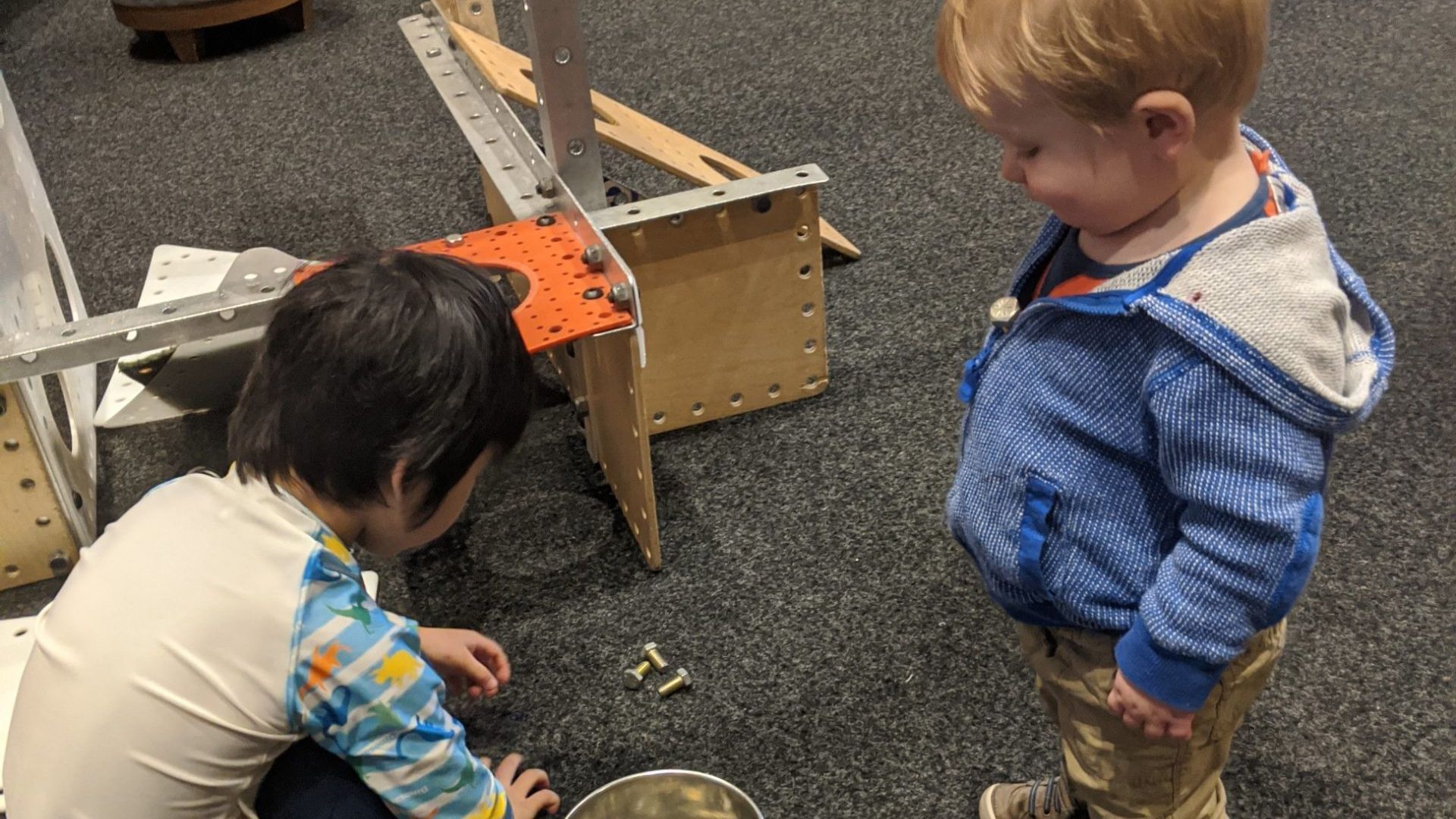 Two young boys working on building a project together