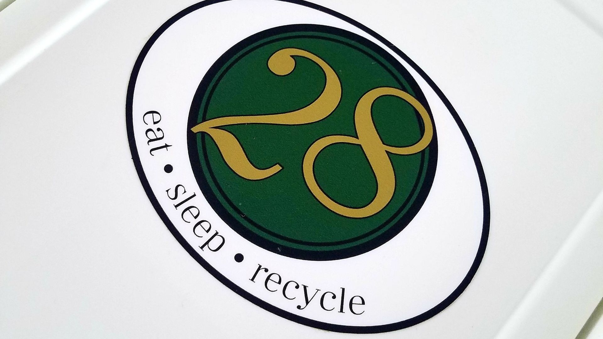A gold "28" in a green circle with the words eat, sleep, recycle