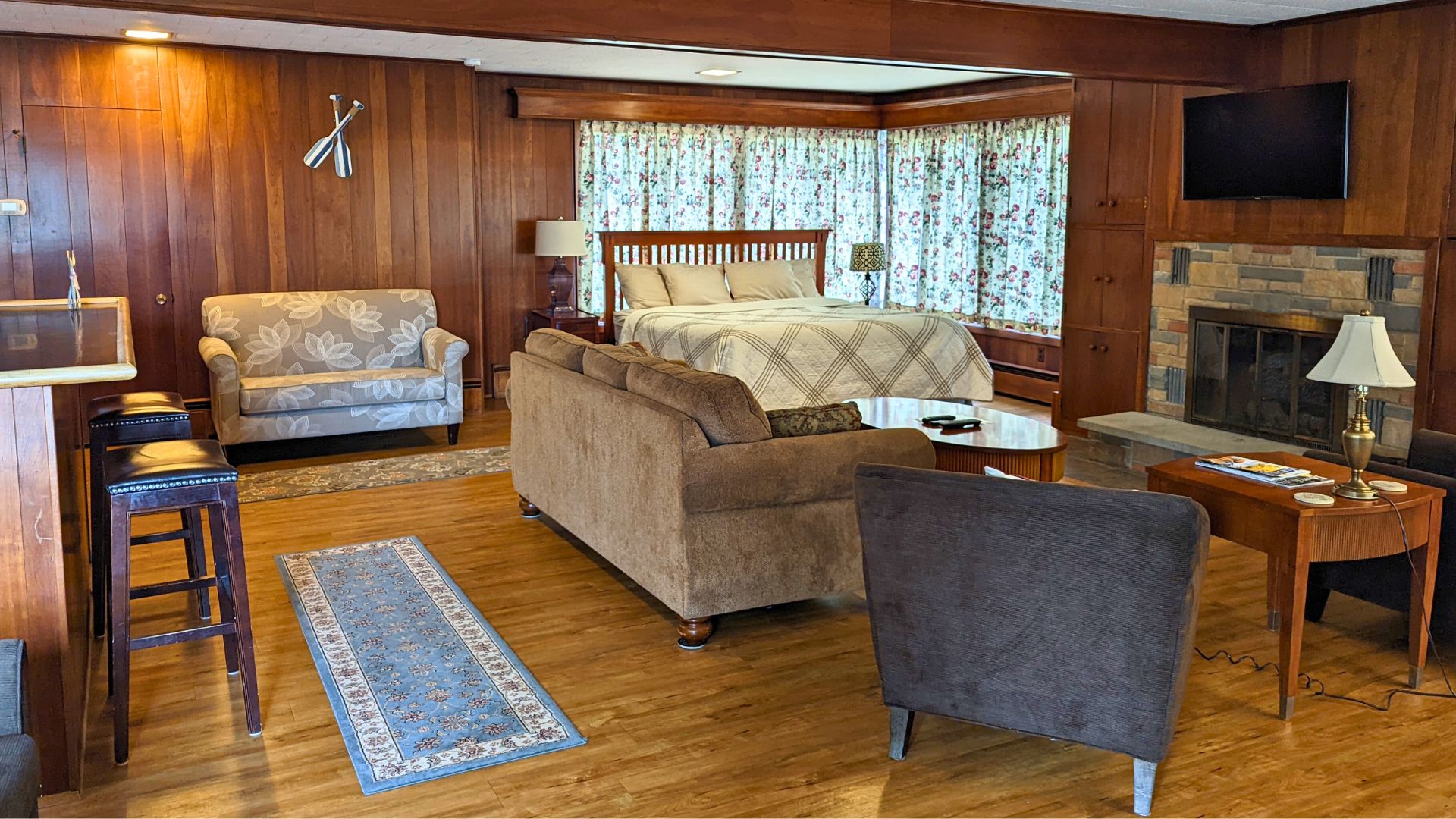 Spacious bedroom suite with bed, couches, sitting chairs, fireplace and bar area