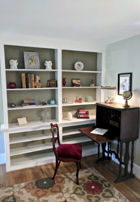 Large, white, built-in bookshelf and brown desk and chair